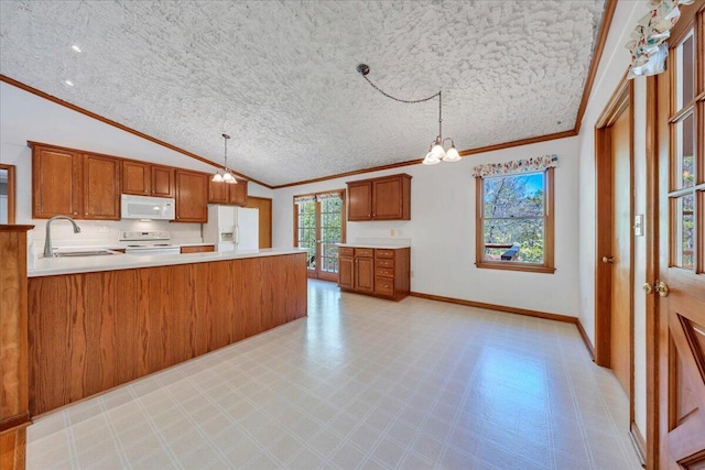 kitchen featuring a sink, white appliances, brown cabinetry, a peninsula, and ornamental molding