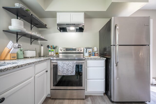 kitchen with appliances with stainless steel finishes, under cabinet range hood, white cabinets, open shelves, and light wood-style flooring
