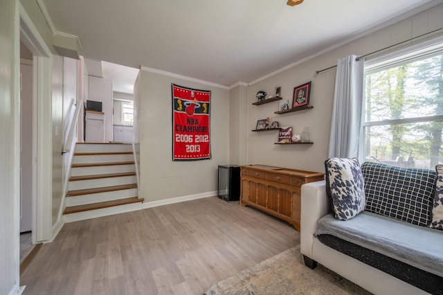 living area featuring wood finished floors, crown molding, stairs, and baseboards