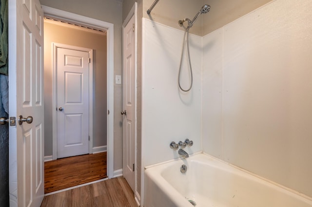 full bath with wood finished floors, tub / shower combination, and baseboards