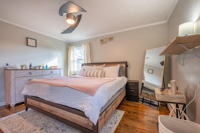 bedroom featuring wood finished floors, crown molding, and a ceiling fan