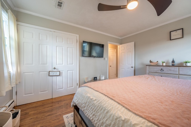 bedroom with wood finished floors, crown molding, a closet, and ceiling fan