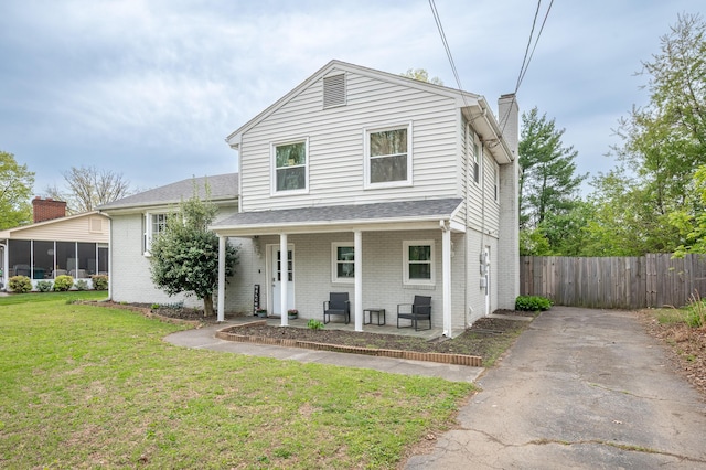 view of front of house featuring brick siding, covered porch, a chimney, and a sunroom