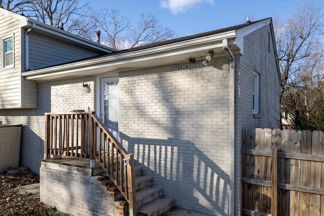 property entrance featuring brick siding and fence