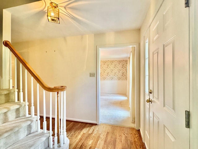 entryway featuring baseboards, stairs, and light wood-style flooring