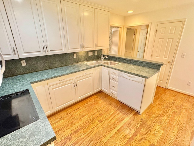 kitchen with white cabinets, a sink, light wood-style floors, dishwasher, and recessed lighting