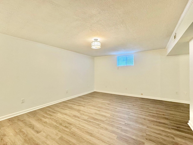 basement with baseboards, light wood-style flooring, and a textured ceiling