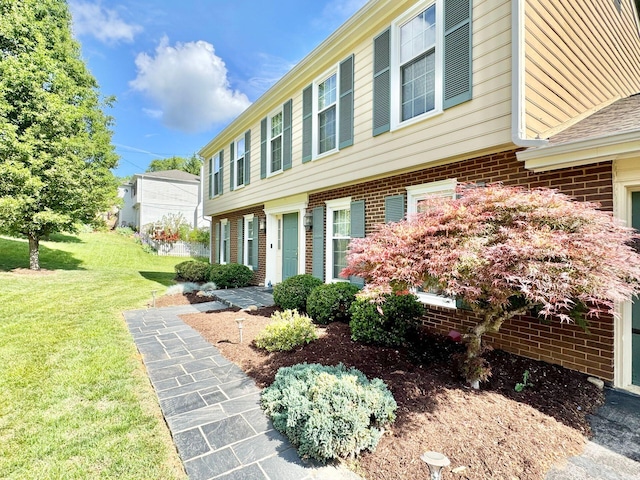 exterior space featuring a yard and brick siding