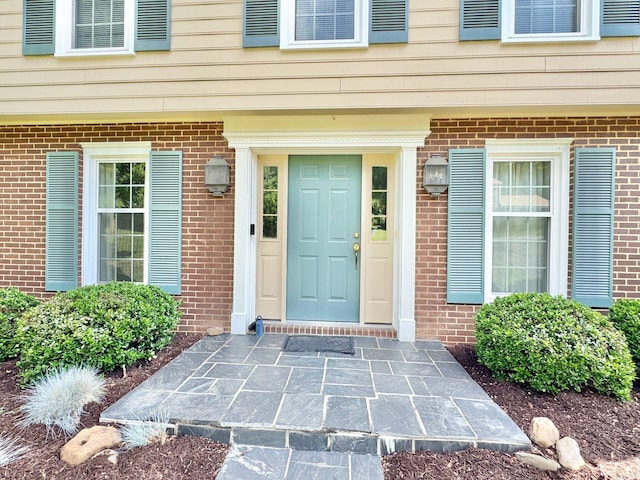 entrance to property featuring brick siding