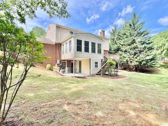 back of house featuring brick siding, a wooden deck, stairway, a chimney, and a patio area
