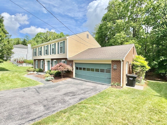 colonial-style house with brick siding, a garage, a front lawn, and driveway
