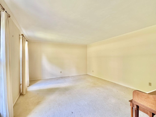 carpeted spare room featuring baseboards and ornamental molding