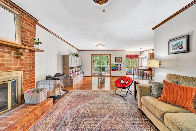living room featuring crown molding, a fireplace, and wood finished floors