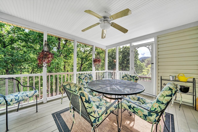 sunroom with plenty of natural light, ceiling fan, and outdoor dining space