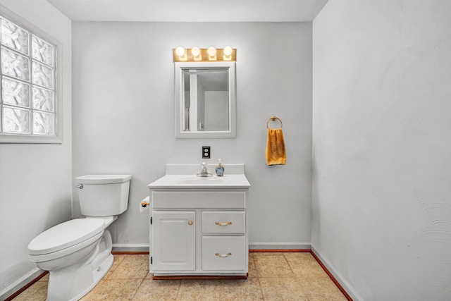bathroom with baseboards, vanity, and toilet