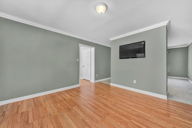 unfurnished room with crown molding, baseboards, and light wood-style floors