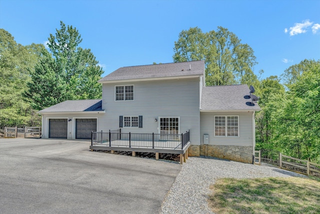 view of front of property with concrete driveway, fence, roof with shingles, and a garage