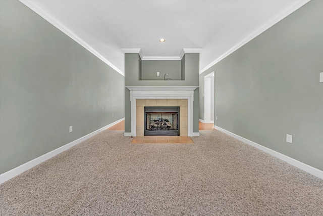 unfurnished living room featuring a tiled fireplace, crown molding, baseboards, carpet flooring, and recessed lighting