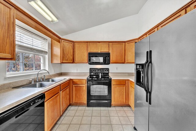 kitchen featuring a sink, light countertops, light tile patterned floors, vaulted ceiling, and black appliances