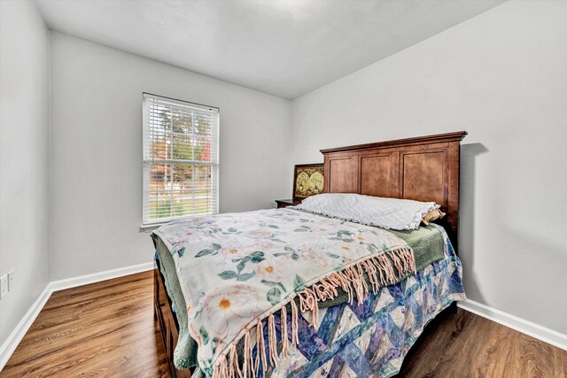 bedroom featuring baseboards and dark wood-type flooring