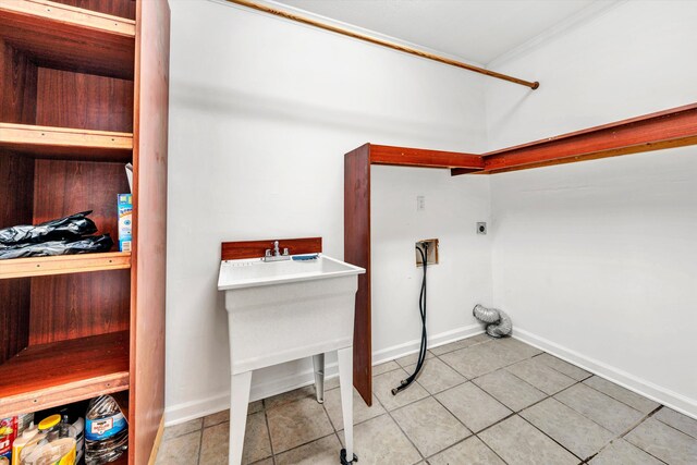 laundry room with laundry area, tile patterned flooring, baseboards, hookup for an electric dryer, and ornamental molding
