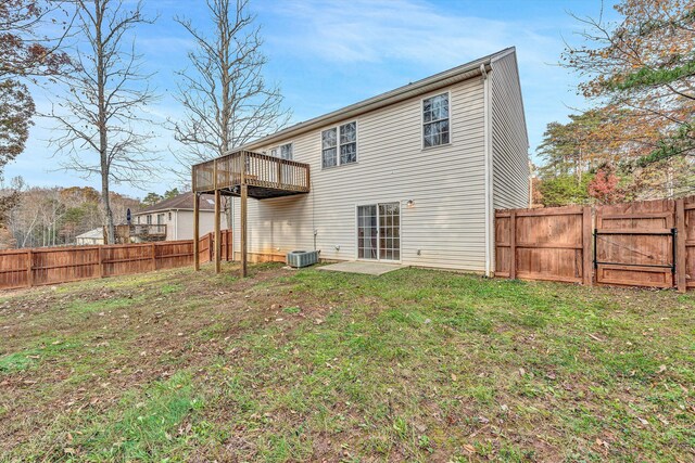 back of house with a deck, a fenced backyard, central AC unit, a gate, and a yard