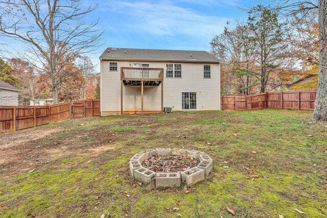 rear view of house with a lawn, a gate, a fenced backyard, and an outdoor fire pit