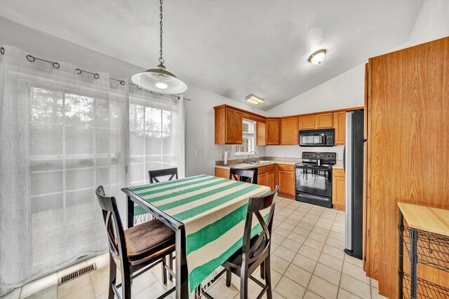 kitchen featuring visible vents, light countertops, black appliances, lofted ceiling, and light tile patterned flooring