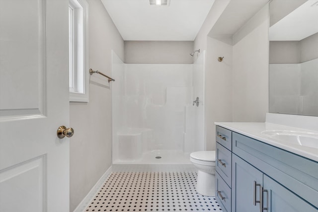 bathroom featuring vanity, toilet, tile patterned floors, baseboards, and a shower