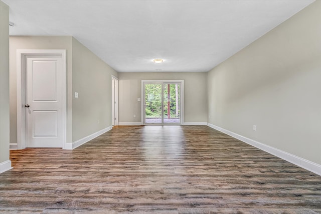 unfurnished living room featuring baseboards and wood finished floors
