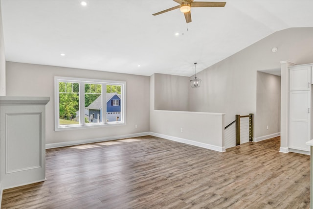 unfurnished living room featuring wood finished floors, baseboards, ceiling fan, recessed lighting, and vaulted ceiling