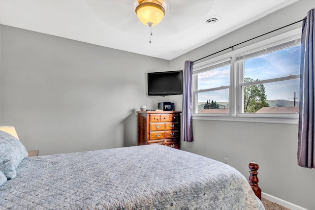 carpeted bedroom featuring baseboards, visible vents, and ceiling fan