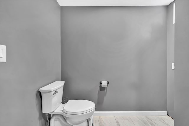 bathroom with toilet and baseboards
