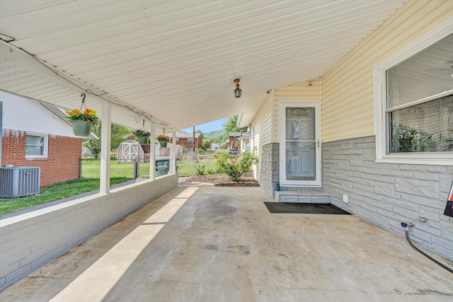 view of patio with central AC, fence, an outdoor structure, and a storage unit