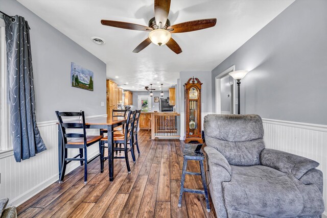 interior space featuring visible vents, a ceiling fan, dark wood finished floors, and wainscoting