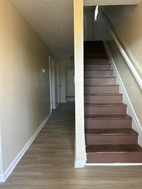 711 Mcdowell Ave NW, Roanoke, VA 24016 - staircase featuring baseboards, a textured ceiling, and wood finished floors