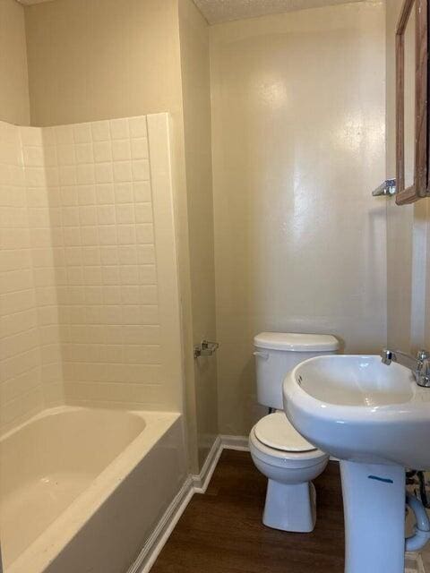 711 Mcdowell Ave NW, Roanoke, VA 24016 - bathroom featuring toilet, baseboards, shower / bath combination, and wood finished floors