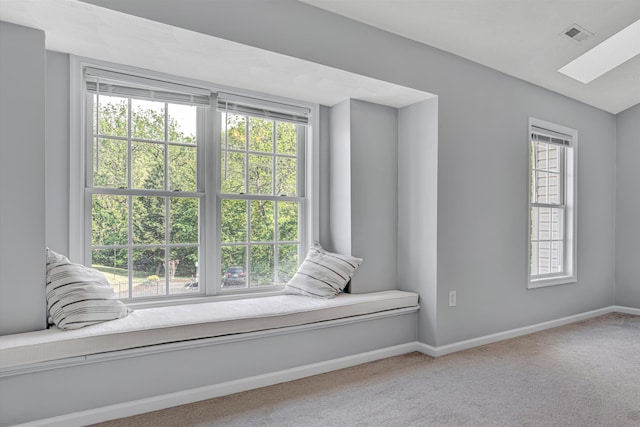 living area with carpet floors, baseboards, a healthy amount of sunlight, and a skylight