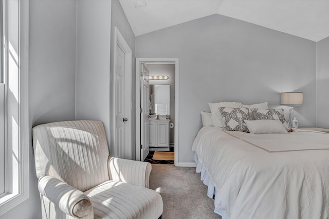 bedroom featuring carpet floors, ensuite bath, and lofted ceiling