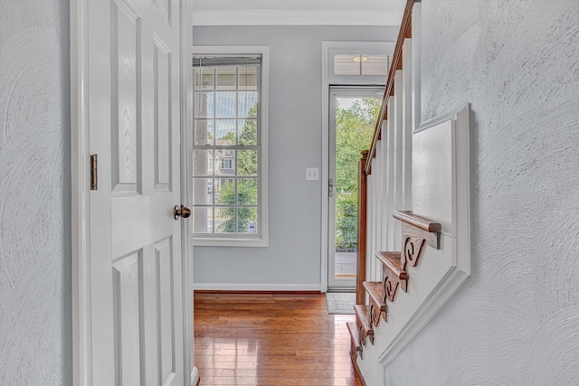 entryway featuring stairs, baseboards, ornamental molding, and wood finished floors