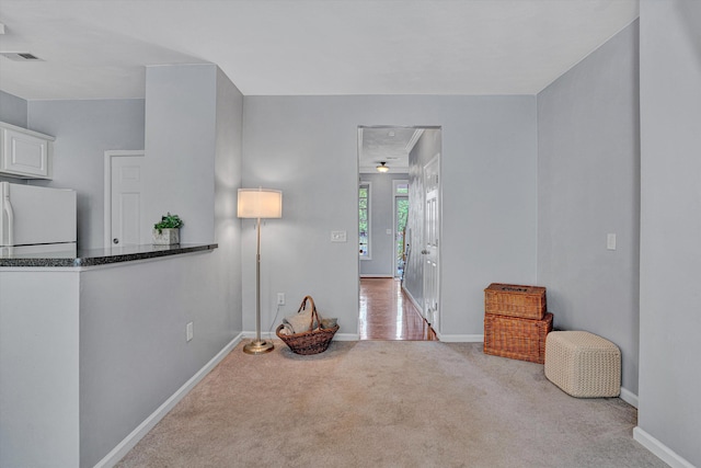carpeted empty room featuring baseboards and visible vents