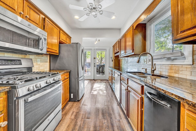 kitchen with brown cabinets, stainless steel appliances, plenty of natural light, and a sink