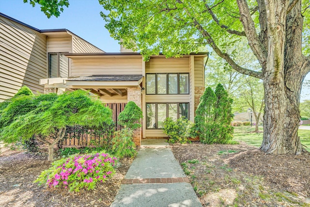 view of exterior entry with a chimney and brick siding