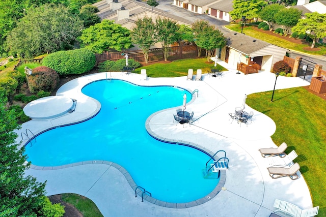 pool with fence, a yard, and a patio area