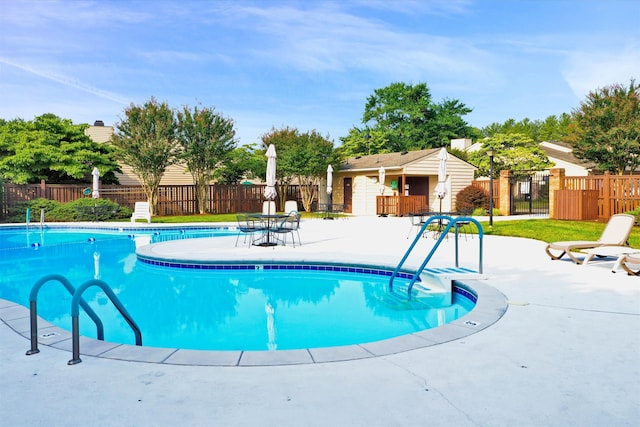 pool featuring fence and a patio
