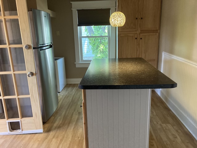 1518 Tazewell Ave SE, Roanoke, VA 24013 - kitchen with light wood-type flooring, freestanding refrigerator, dark countertops, baseboards, and pendant lighting