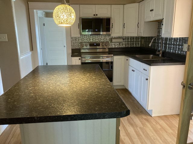 1518 Tazewell Ave SE, Roanoke, VA 24013 - kitchen featuring appliances with stainless steel finishes, a sink, dark countertops, and light wood-type flooring