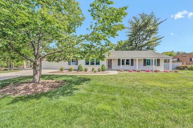 ranch-style house featuring concrete driveway, a front lawn, and an attached garage