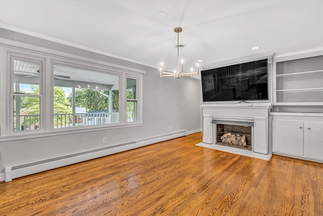unfurnished living room with a baseboard radiator, a chandelier, a fireplace, crown molding, and wood finished floors