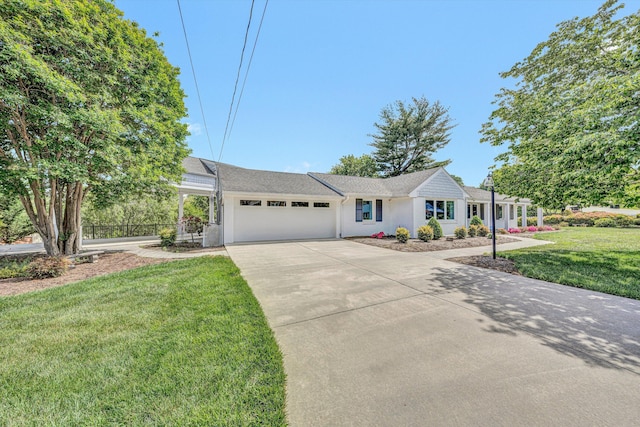 ranch-style home featuring an attached garage, concrete driveway, a front lawn, and stucco siding